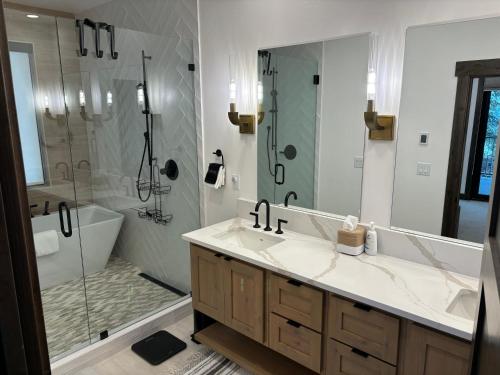 a bathroom with a shower and a sink and a tub at Whitefish Mountain Marvel Ski in Ski out- New Build, Pool Table, Hot Tub and Sleeps 19! in Whitefish