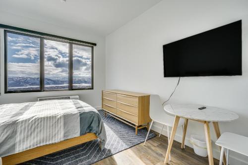 a bedroom with a bed and a desk and a flat screen tv at Ski-InandSki-Out Park City Studio Community Hot Tub in Park City