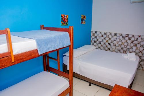 a room with two bunk beds and a blue wall at Pousada Flat Castor in Natal