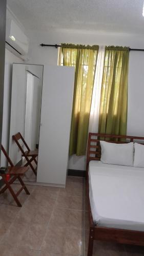 a bedroom with a bed and a mirror and a window at Villa Copthall in Roseau