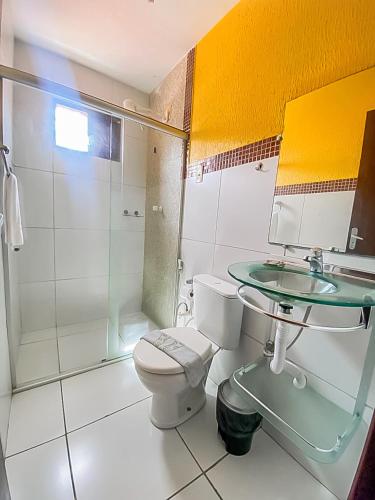 a bathroom with a toilet and a sink and a shower at Pousada Flat Castor in Natal