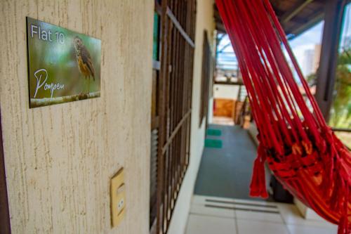 a sign on a wall next to a hallway at Pousada Flat Castor in Natal