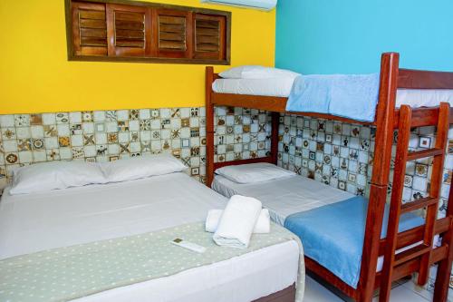 a room with two bunk beds and a table at Pousada Flat Castor in Natal
