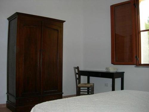 カブラスにあるAgriturismo Sannorannaのベッドルーム1室(ベッド1台、キャビネット、デスク付)