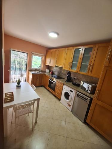 a kitchen with wooden cabinets and a table and a sink at Casa do Alto in Terras de Bouro