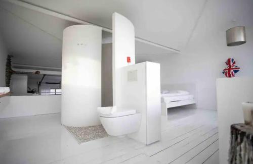 a white bathroom with a toilet in a room at Whiteloft in Neuwied