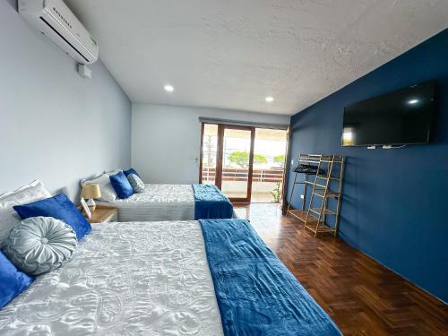 sypialnia z 2 łóżkami i telewizorem z płaskim ekranem w obiekcie Beachfront w/ pool & rancho - Casa Coral w mieście Puntarenas
