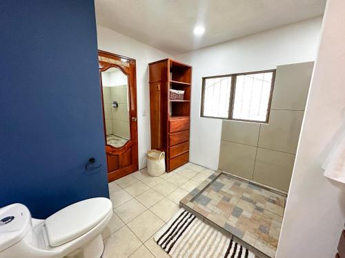 a bathroom with a toilet and a shower at Beachfront w/ pool & rancho - Casa Coral in Puntarenas