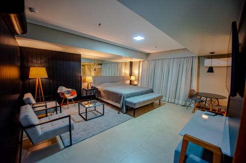a hotel room with a bed and a living room at HOTEL GRAN PREMIUM PLAZA LTDA in Muriaé