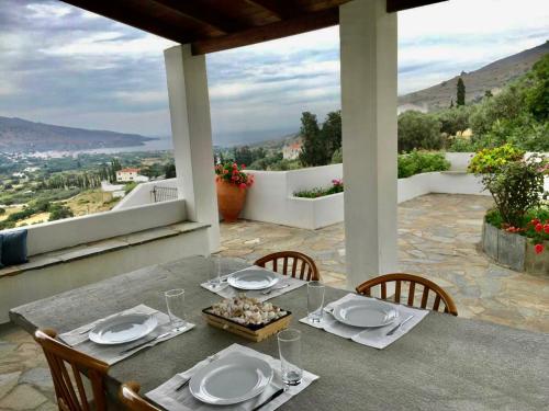 una mesa con platos y vasos en la parte superior de un balcón en Villa Sis en Aïdhónia