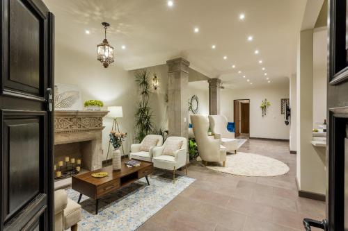 - un salon avec des chaises et une cheminée dans l'établissement Casa Cielo, 4-Story Luxury Home with Rooftop Hot Tub & AC, à San Miguel de Allende