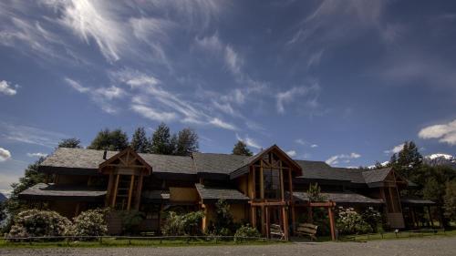 a large log cabin with a cloudy sky at Yelcho en la Patagonia in Chaitén