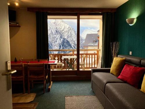 a living room with a couch and a view of a mountain at Résidence Soleil - 2 Pièces pour 5 Personnes 384 in Vénosc