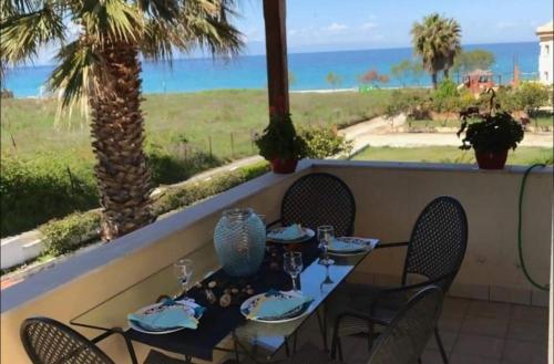 a table and chairs with a view of the ocean at Posidi pool apartment in Possidi