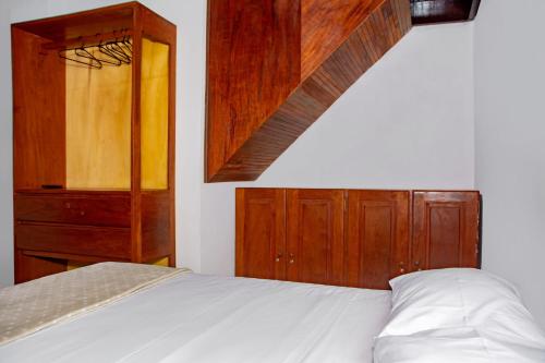 a bedroom with a bed and a wooden cabinet at Pousada Flat Castor in Natal