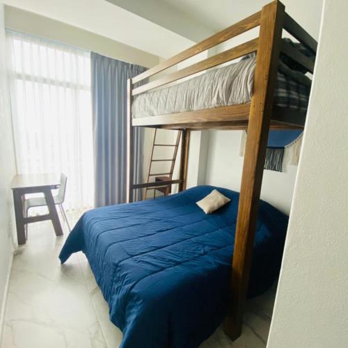 - une chambre avec des lits superposés et un couvre-lit bleu dans l'établissement Depto céntrico y vista increíble, à Mexico