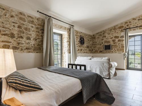 コーミゾにあるBRAMASOLE Charming Houseの石壁のベッドルーム1室(ベッド2台付)