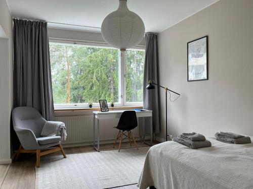 1 dormitorio con cama, escritorio y ventana en Garden city studio, en Espoo