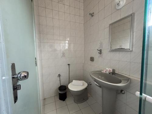 a small bathroom with a sink and a toilet at Carlton Express Imbiara in Araxá