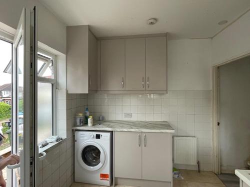 a kitchen with a washer and a washing machine at Dudley court, Lower Road in Harrow on the Hill