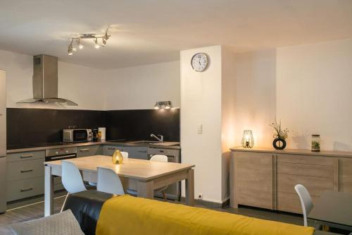 une cuisine et une salle à manger avec une table et une horloge dans l'établissement Chez Jo, Magnifique appartement T2 à Rodez, à Rodez