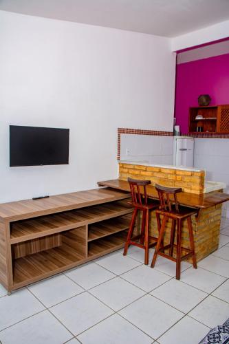 a kitchen with a table and two chairs and a tv at Pousada Flat Castor in Natal