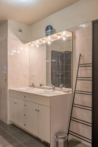 une salle de bain avec deux lavabos et un miroir dans l'établissement Chez Jo, Magnifique appartement T2 à Rodez, à Rodez