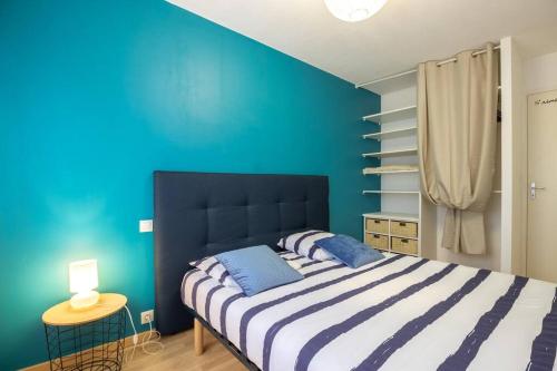 une chambre avec un lit avec un mur bleu dans l'établissement Chez Jo, Magnifique appartement T2 à Rodez, à Rodez