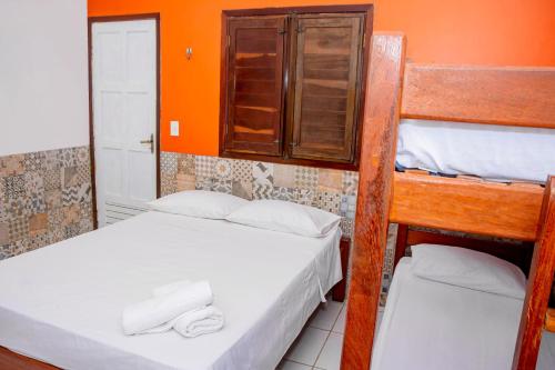 two bunk beds in a room with an orange wall at Pousada Flat Castor in Natal