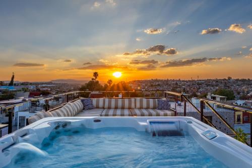 - un bain à remous sur le toit d'un immeuble avec vue sur le coucher du soleil dans l'établissement Casa Cielo, 4-Story Luxury Home with Rooftop Hot Tub & AC, à San Miguel de Allende