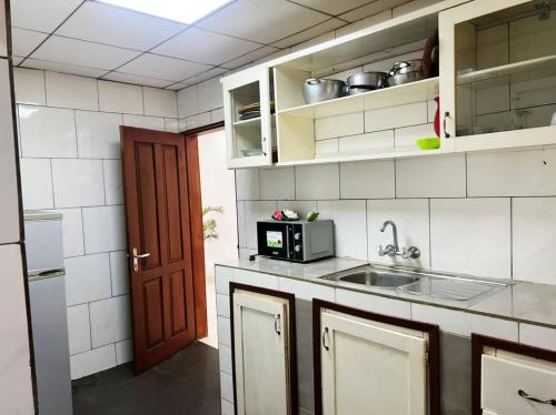 a kitchen with a sink and a microwave at DAC IMMOBILIER in Yaoundé