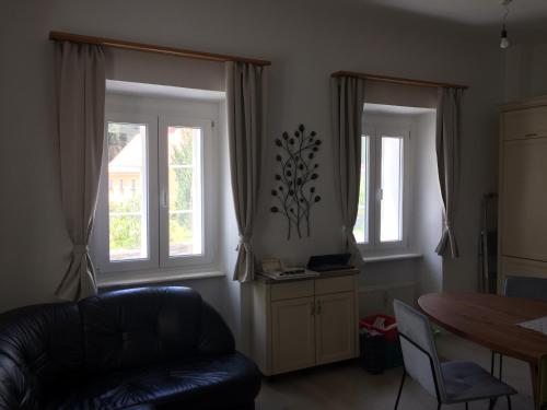 a living room with two windows and a couch at SistiHome in Kleinfeistritz