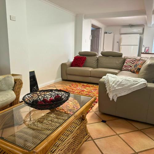 a living room with a couch and a table at Memory Lane Accommodation in Mount Tamborine