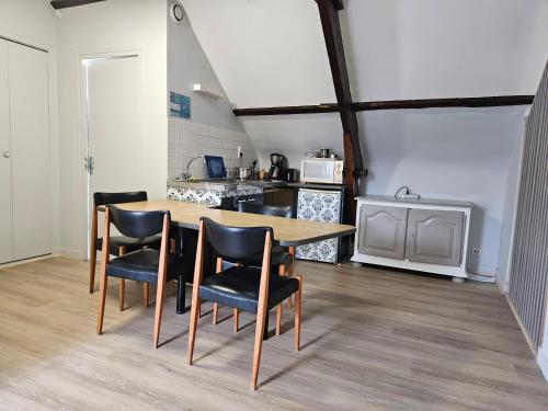 une cuisine avec une table et des chaises dans une pièce dans l'établissement Appartement du haut 1, à Cordemais