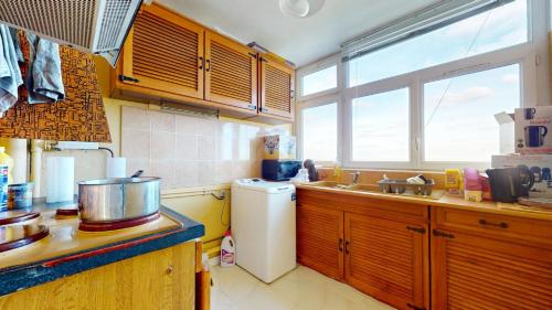 La cuisine est équipée d'un évier et d'un réfrigérateur blanc. dans l'établissement Bel appartement meublé (Evry), à Évry-les-Châteaux