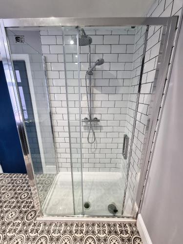 a shower with a glass door in a bathroom at Tiffy's Place in Blackpool