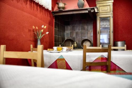 a table in a red room with a table and chairs at Hotel Eladia in Cangas de Onís