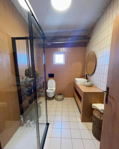 a bathroom with a toilet and a glass shower at Casa Mimosa - Algarve in Portimão