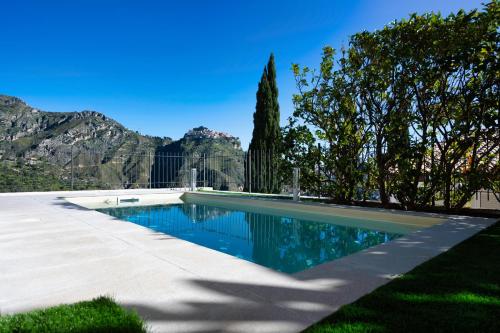 una piscina en un patio con montañas al fondo en Casa Mathea, en Taormina