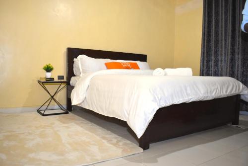 a bedroom with a large bed with a side table at The Zen One Bedroom,Milimani, Nakuru in Nakuru