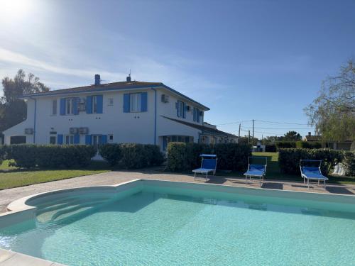 a house and a swimming pool in front of a house at Garden Hotel Alghero in Fertilia
