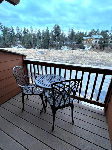 a table and chair on a deck with a view of the beach at Canyon Plaza Premier Studios and Apts-South Rim in Tusayan