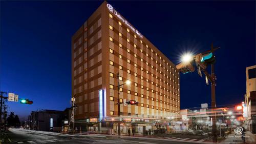 a tall building with lights on a street at night at Daiwa Roynet Hotel Hachinohe in Hachinohe