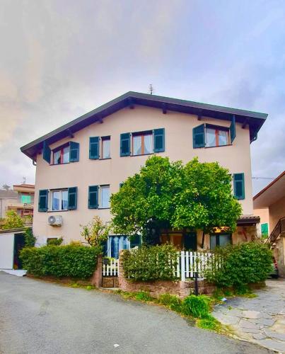 a white house with a tree in front of it at Villa Iris in Casarza Ligure
