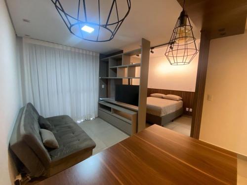 a living room with a couch and a bed and a table at Monte Carmel in Ribeirão Preto