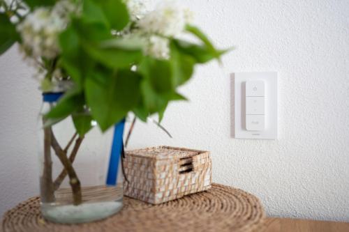a vase with flowers in it next to a light switch at Ferienwohnung am Siglhof in Samerberg