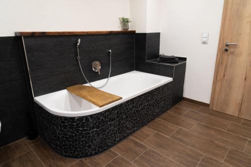 a bath tub in a bathroom with a wooden floor at Ferienwohnung am Siglhof in Samerberg