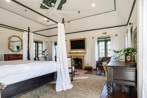 a bedroom with a canopy bed and a fireplace at Historic Maryland Gatehouse Pool Access and Balcony in Cockeysville