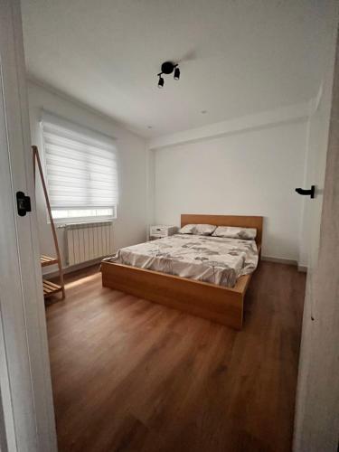Schlafzimmer mit einem Bett und Holzboden in der Unterkunft El Rincon in León