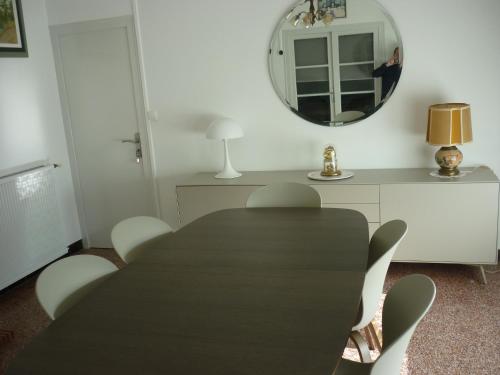 een eetkamer met een tafel en stoelen en een spiegel bij maison 20mn de la mer in Aigrefeuille-dʼAunis